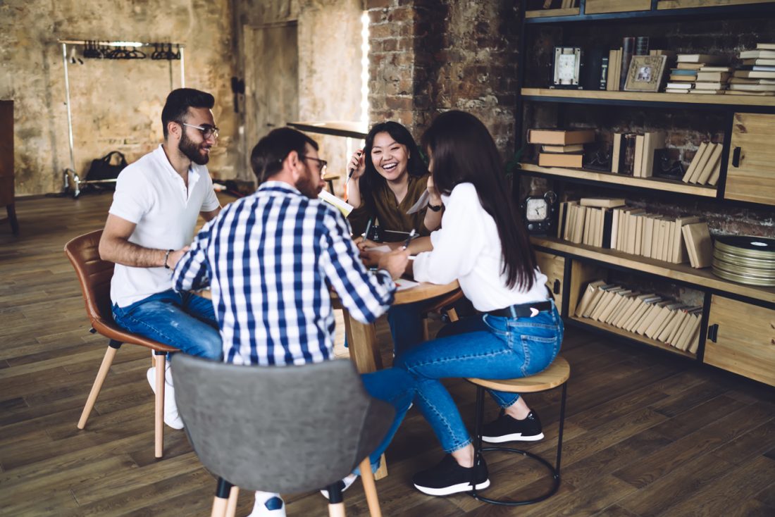 Group Of Cheerful Colleagues Talking In Office