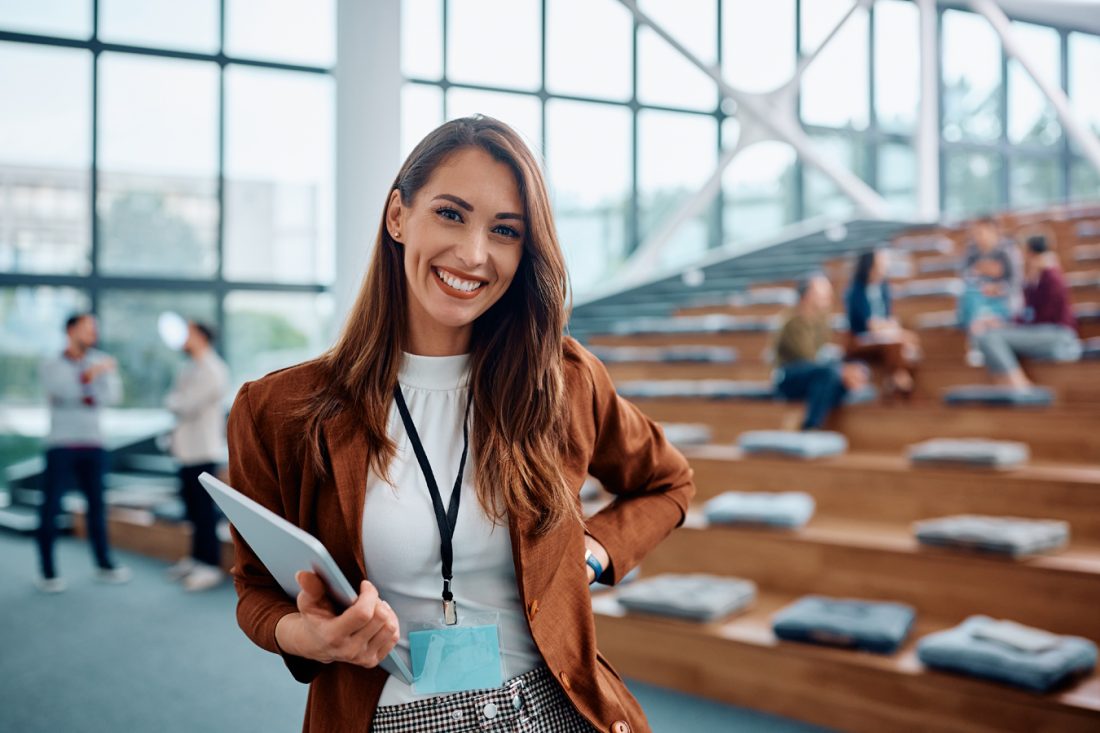 Happy Female Entrepreneur Attending Business Seminar In Conference Hall And Looking At Camera.