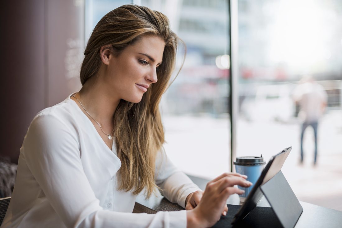 Young Businesswoman In A Cafe Using Tablet