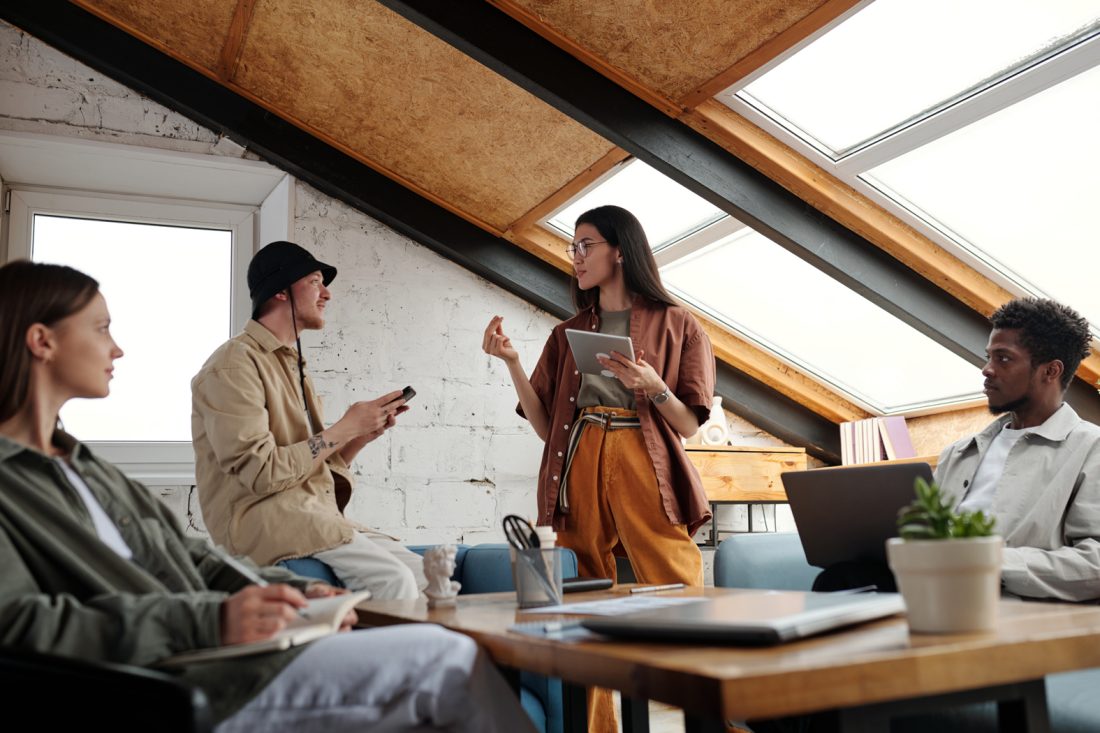 Young Confident Businesswoman With Tablet Explaining Her Idea To Colleague